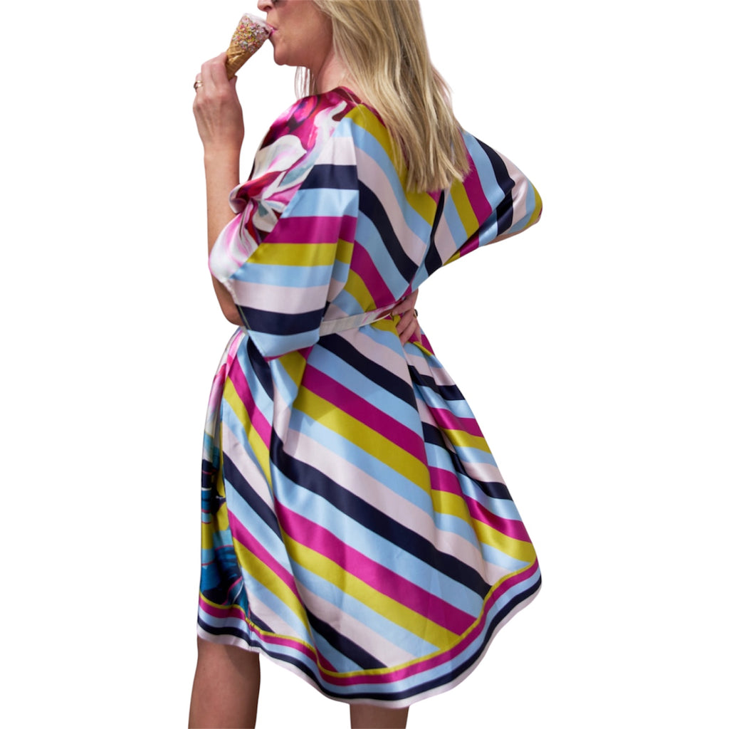 Woman wearing a colorful striped dress on a white background