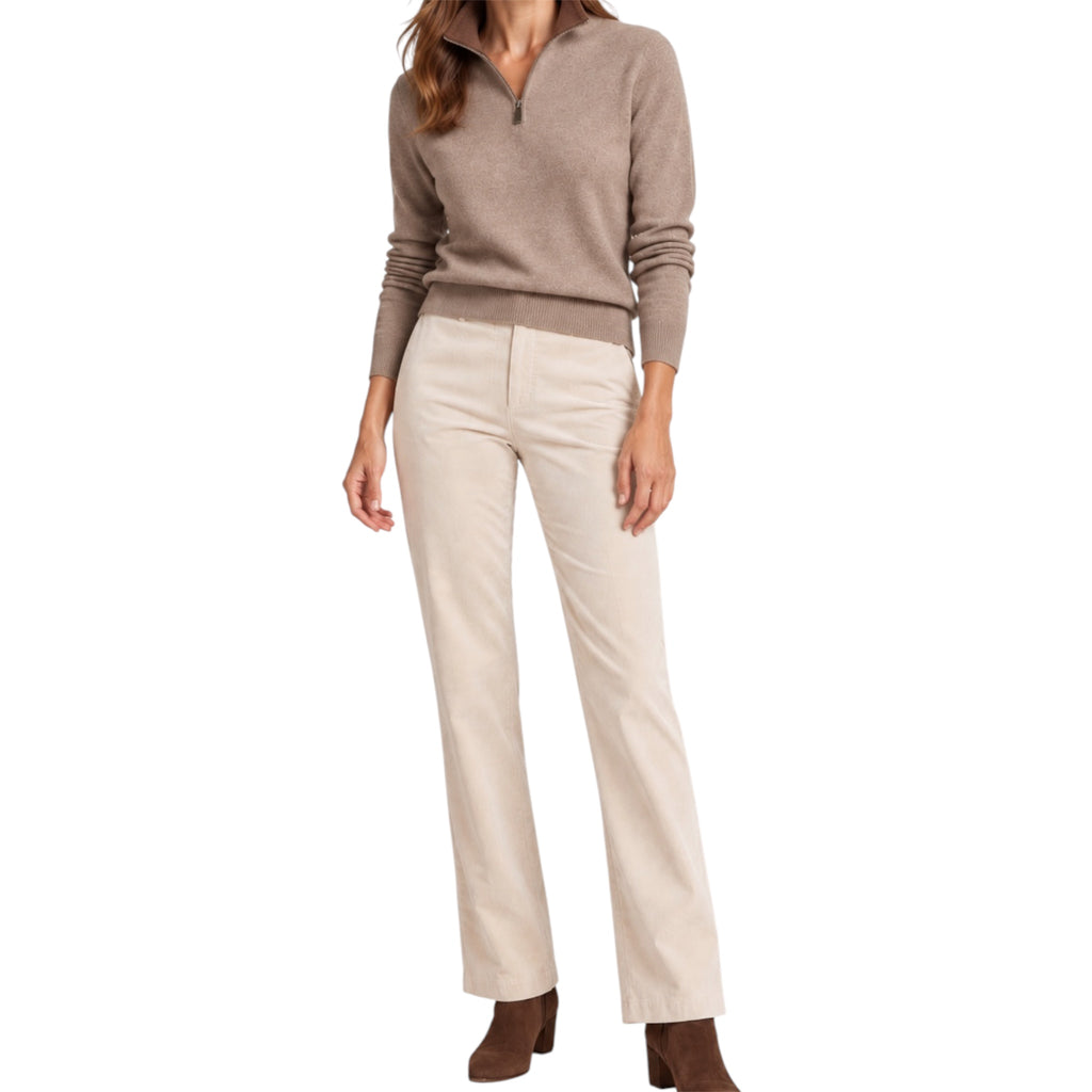 A woman modeling a taupe quarter-zip cashmere sweater and straight-leg cream corduroy pants with brown ankle boots, shown against a plain white studio background.