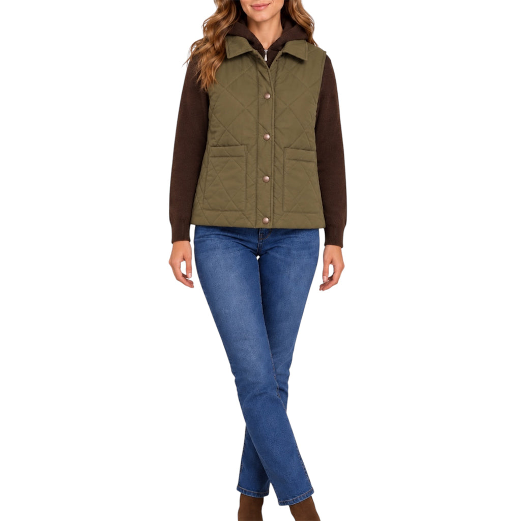 A woman modeling an olive green quilted sleeveless vest over a dark brown long-sleeve shirt and blue jeans, shown against a plain white background.
