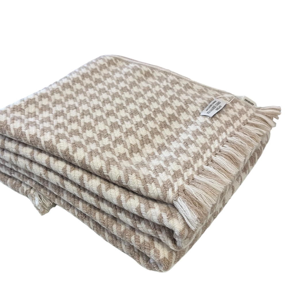 A beige and white 100% pure cashmere throw with a houndstooth pattern, displayed folded on a surface.