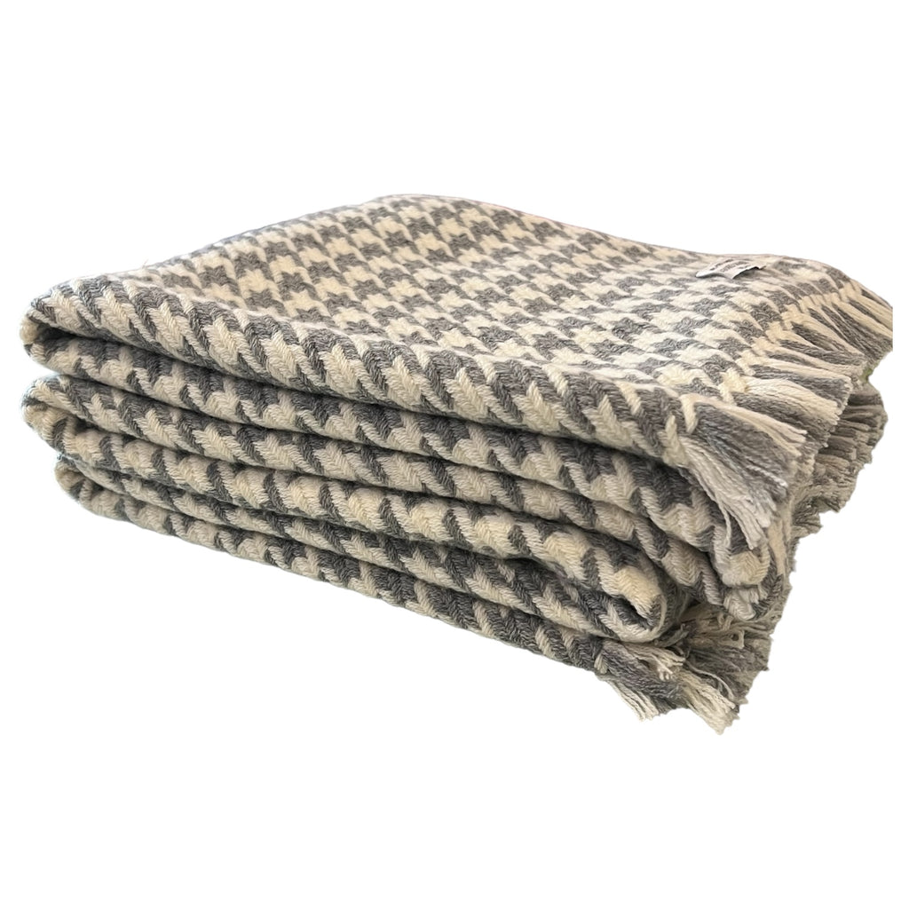 A folded 100% pure cashmere throw in slate grey and white with a houndstooth pattern.