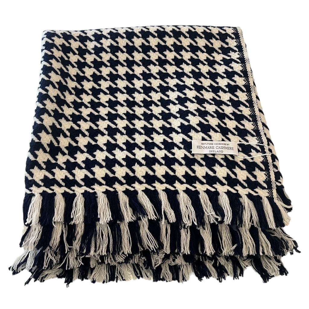 A navy and white checkered 100% pure cashmere throw with fringes displayed on a white background