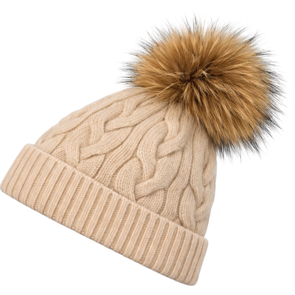 Side view of sand cable knit cashmere beanie with detachable raccoon fur pom pom